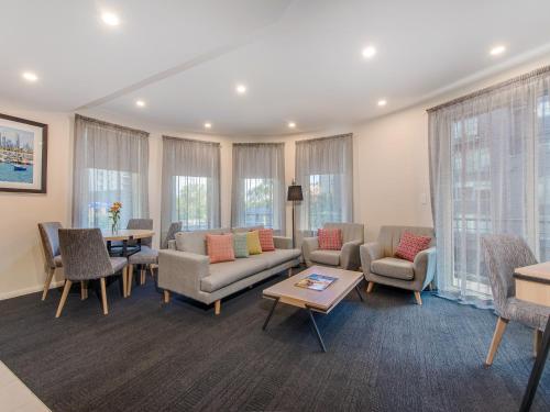 墨尔本Melbourne South Yarra Central Apartment Hotel Official的带沙发、椅子和桌子的客厅