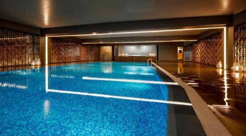 京都京都丽嘉皇家酒店的大楼内一个蓝色的大型游泳池