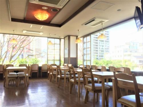 松本松本万屋酒店的用餐室设有桌椅和窗户。