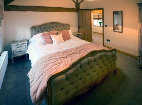 AstburyHoneysuckle Cottage, Drift House Holiday Cottages的一间卧室配有一张大床和枕头