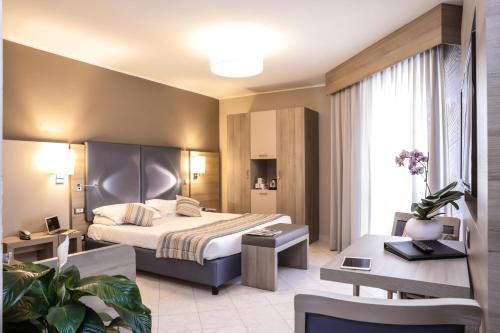 阿尔盖罗阿尔玛迪阿尔盖罗酒店的配有一张床和一张书桌的酒店客房