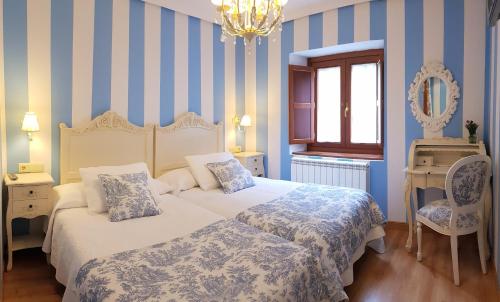 拉瓜迪亚Legado de Ugarte, Casa Rural的一间卧室配有两张蓝色和白色条纹的床