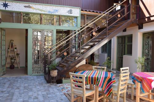 圣地亚哥Eco-Hostal Tambo Verde的庭院设有楼梯,位于带桌椅的房屋内