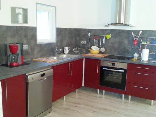 布尔拉茨Gîte de Marie的一间带红色橱柜和水槽的厨房