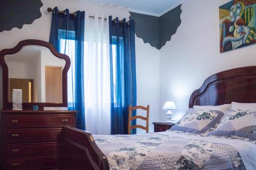 蓬塔德尔加达Apartamento Sandra的一间卧室配有一张床、梳妆台和镜子