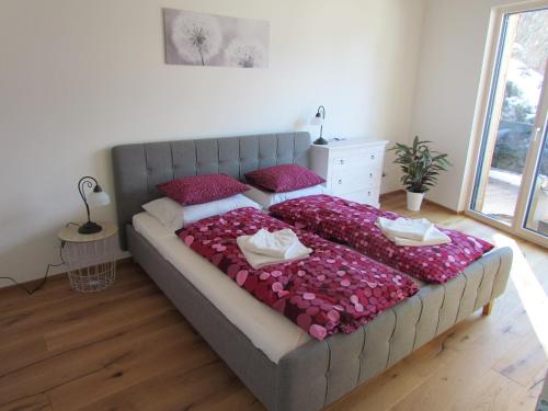 罗孚尔Scheffsnoth 142的卧室配有一张带粉红色枕头的大床