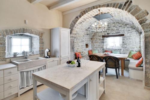 莫托文Casa Meloni的厨房配有桌子和砖墙