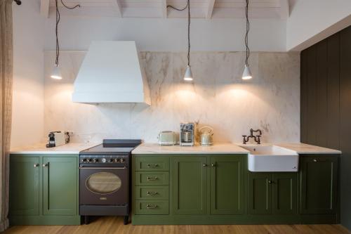 费斯卡尔德宏North Point Houses的厨房配有绿色橱柜和水槽