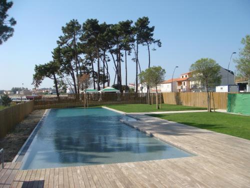 艾利亚德亚罗萨Apartamento de Mar y Playa en Illa de Arousa的一个带围栏和树木的庭院内的游泳池