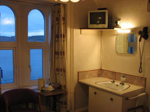 奥本兰嘉丝汀酒店的一间带水槽的浴室和墙上的电视