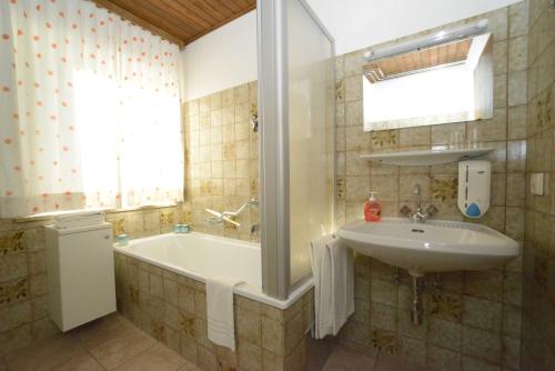 巴特霍夫加施泰因安格度假酒店的浴室配有盥洗盆和浴缸。
