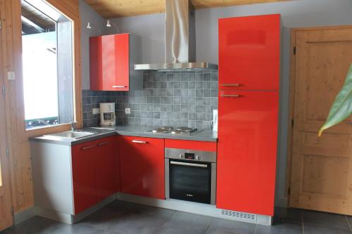 莱热阿尔卑斯花卉小屋酒店的厨房配有红色橱柜和红色冰箱