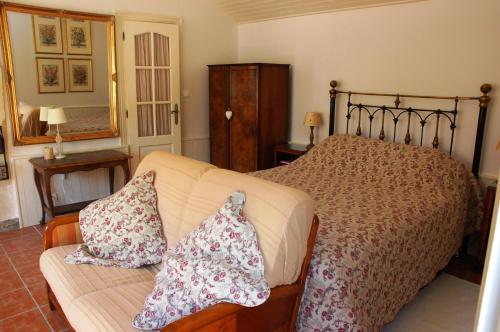 BrionLe Logis du Pressoir Chambre d'Hotes Bed & Breakfast in beautiful 18th Century Estate in the heart of the Loire Valley with heated pool and extensive grounds的一间卧室配有一张床和一张带枕头的沙发。
