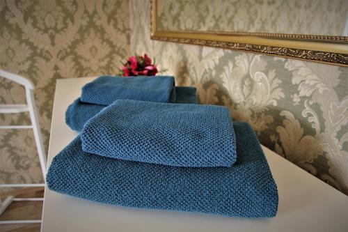 卡罗维发利Petřín No. 1的三条蓝色毛巾坐在一张桌子上,带镜子