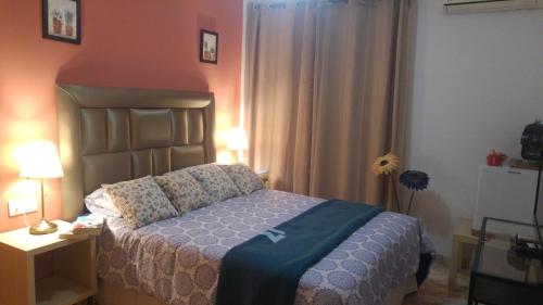 Estepona森特纳里欧酒店的一间卧室配有一张床和一张带台灯的桌子