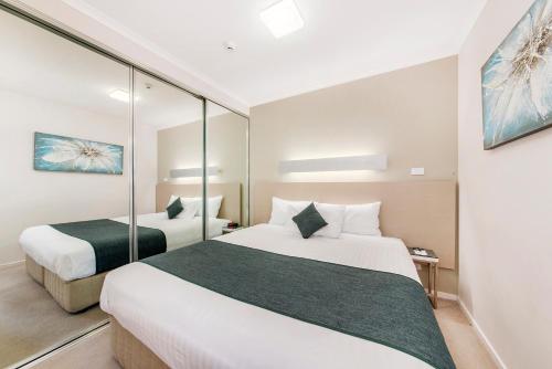 堪培拉塔格拉诺精舍的酒店客房,设有两张床和镜子