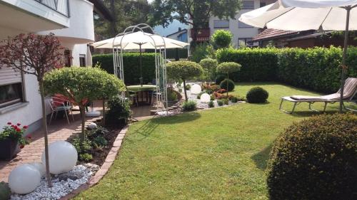 珀丽Ferienwohnung Guth的花园设有凉亭、长凳和遮阳伞。
