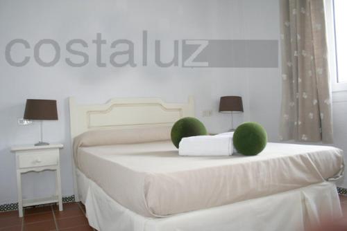 埃尔波提尔Apartamentos Aguadulce El Portil的白色卧室配有一张绿球床