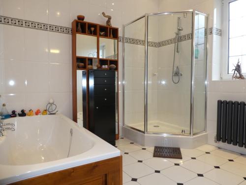 爱丁堡The Cairn Residence的带浴缸和玻璃淋浴间的浴室。