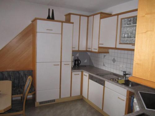 Terfens费瑞豪斯玛瑞提娜度假屋的小厨房配有白色橱柜和水槽