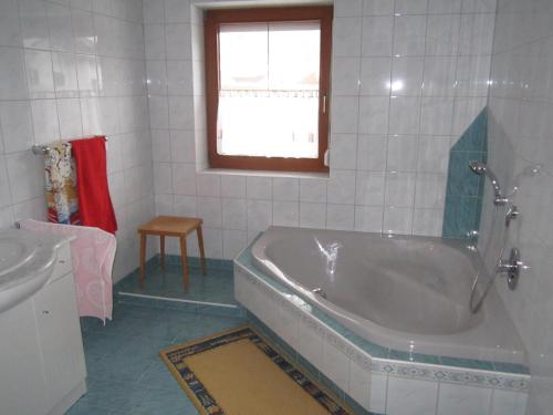 Terfens费瑞豪斯玛瑞提娜度假屋的带浴缸、水槽和窗户的浴室