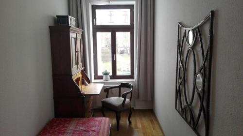 莱比锡Bastians Herberge的客房设有书桌、窗户和椅子。