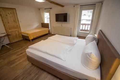 菲施巴豪Pension Oberwirt的一间卧室配有两张床和电视。