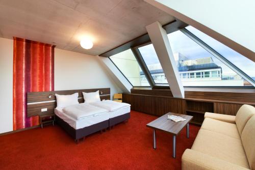 维也纳Simm's Hotel - cityhotel next to Metro U3的一间卧室配有一张床和一个沙发