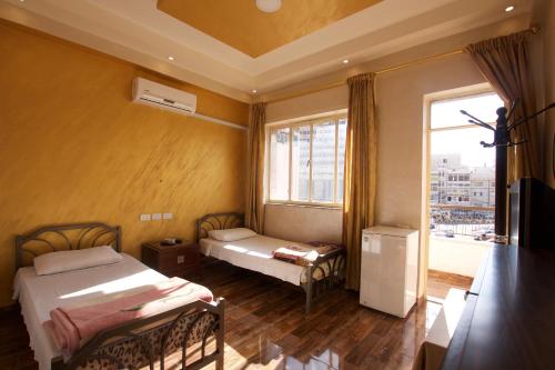 安曼Sun Rise Hotel & Hostel & Tours的一间卧室设有两张床和大窗户