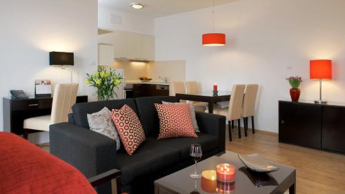 布达佩斯Escala Hotel & Suites的客厅配有沙发和桌子
