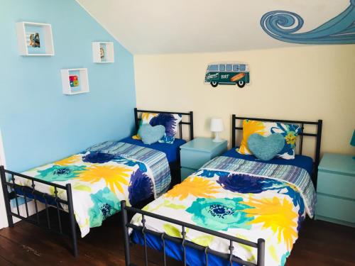 菲盖拉-达福什The Paintshop Hostel的蓝色墙壁客房的两张床