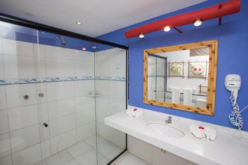 普拉亚多Porto da Lua Boutique Hotel的带淋浴、盥洗盆和镜子的浴室