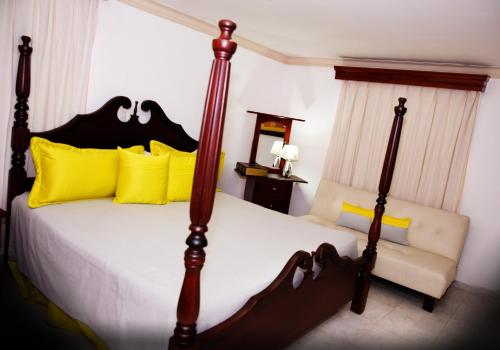 圣地亚哥洛斯卡巴洛杉花园酒店的一间卧室配有一张带黄色枕头的大床