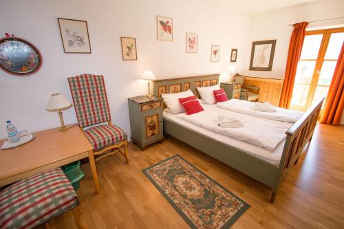 巴特莱辛哈尔玛德尔鲍尔高山旅馆的卧室配有1张床、1张桌子和1把椅子