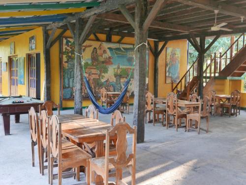 莫约加尔帕El Peregrino的一间带木桌、椅子和吊床的餐厅