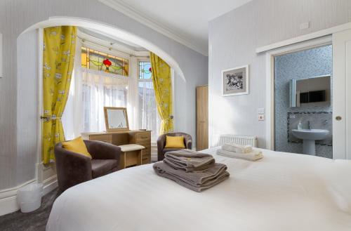 布莱克浦The Beechcliffe Hotel - Over 35's Only的一间带白色大床的卧室和一间浴室
