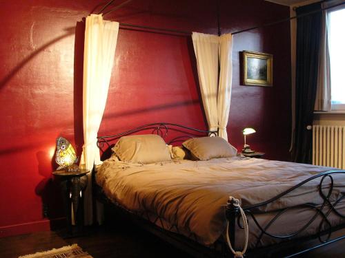 布鲁日简夫人住宿加早餐酒店的一间卧室设有一张红色墙壁的大床