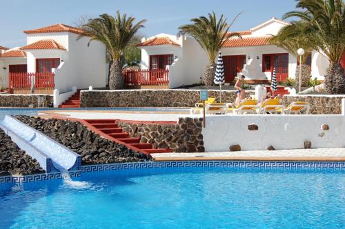 卡勒达德福斯特卡斯蒂约海滩洋房酒店的一座别墅,设有游泳池和棕榈树