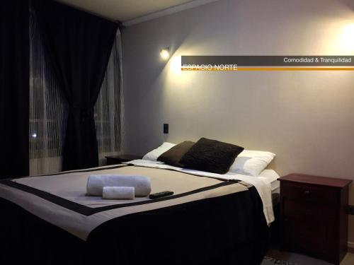 伊基克Espacio Norte - Iquique Cavancha的卧室配有一张挂有墙上标志的床