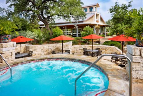 圣安东尼奥Hyatt Vacation Club at Wild Oak Ranch的房屋前设有带桌子和遮阳伞的游泳池