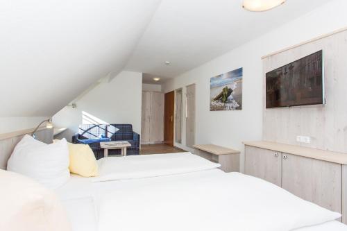 诺尔多夫海风轻拂酒店的一间卧室设有两张床,墙上配有电视。