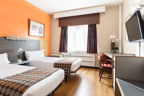 莱昂Crisol Quindós的酒店客房配有两张床和一张书桌
