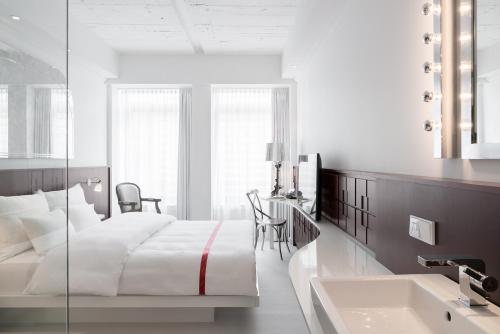 杜塞尔多夫如比可可杜塞尔多夫酒店的白色卧室设有床铺和水槽