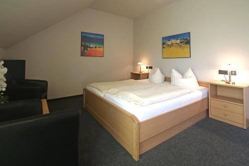 奥斯纳布吕克布希-阿特酒店的配有一张床和一把椅子的酒店客房