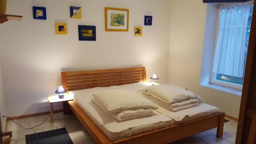 Lietzow豪斯希布里克因赛尔鲁艮公寓的一间卧室配有一张带枕头的床,墙上挂有图片