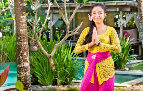 乌布Arimba at Bisma的穿着黄色和粉红色衣服的女子做瑜伽