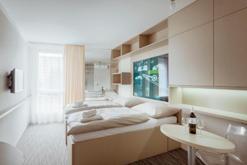 奥洛穆茨Smarthotel Nezvalova Archa的一间卧室配有两张床和一张桌子