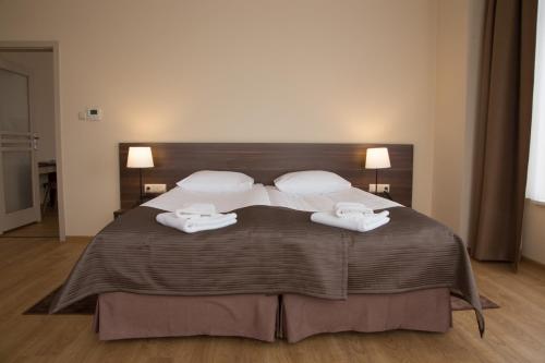 扎雷Glas-Hotel 4*的一间卧室配有一张大床和两条毛巾
