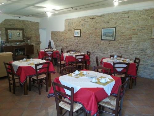 托迪以波尔格托农家乐的用餐室配有红色和白色桌布的桌子