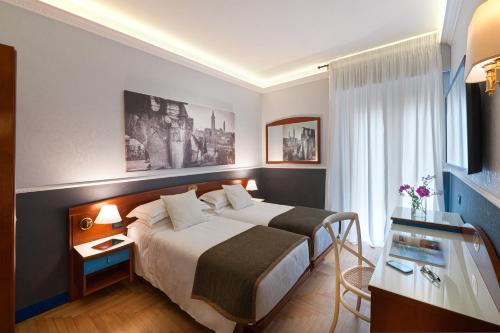 维罗纳Mastino Rooms的酒店客房设有一张大床和一张书桌。